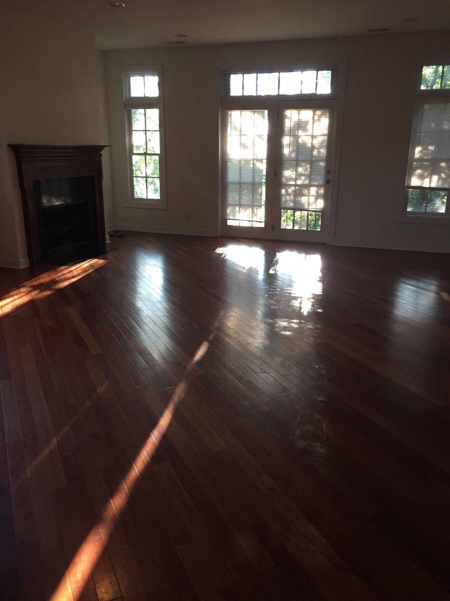 an empty living room with wooden floors and a fireplace