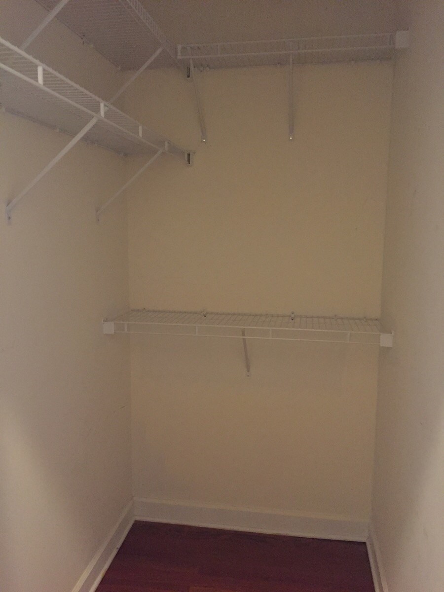 a empty closet with a red carpet and white walls