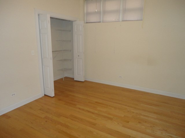 an empty room with wooden floors and a closet