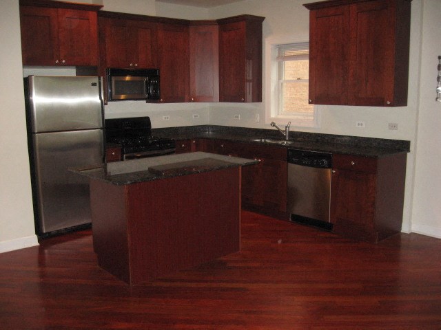 an empty kitchen with a stainless steel refrigerator
