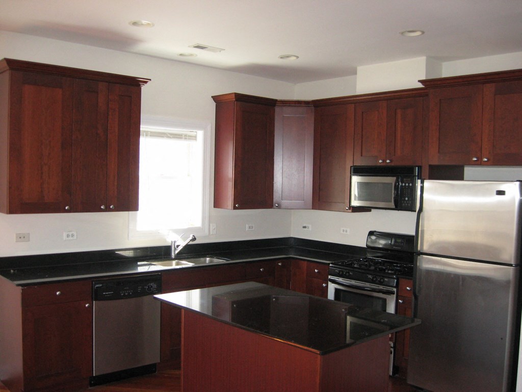 a kitchen with black counter tops and stainless steel appliances