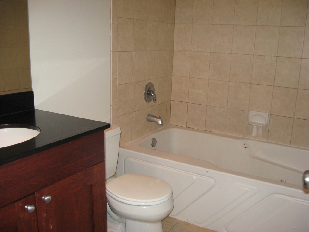 a bathroom with a toilet and a tub and a sink