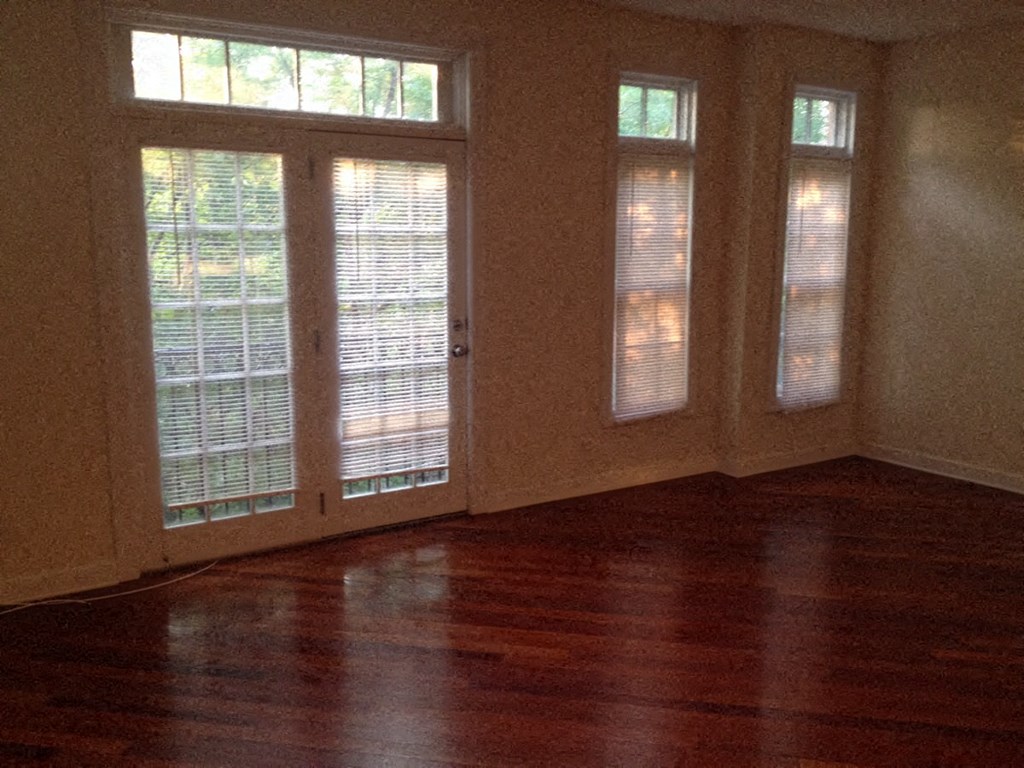 a living room with wood floors and windows