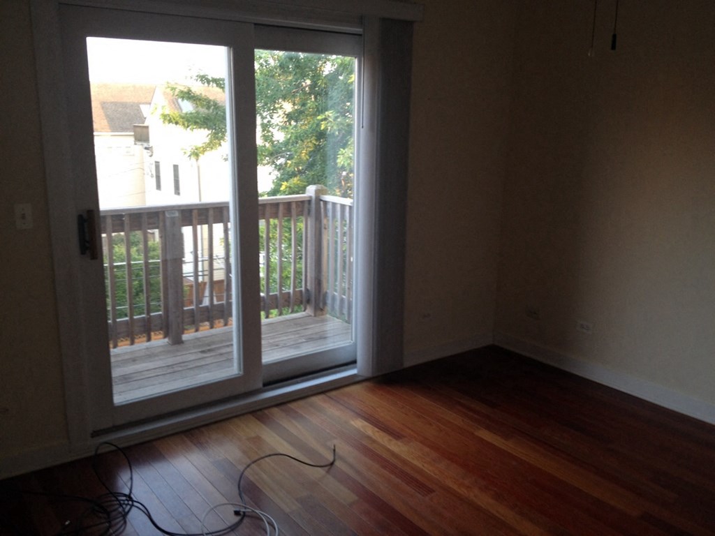 an empty living room with sliding glass doors to a balcony