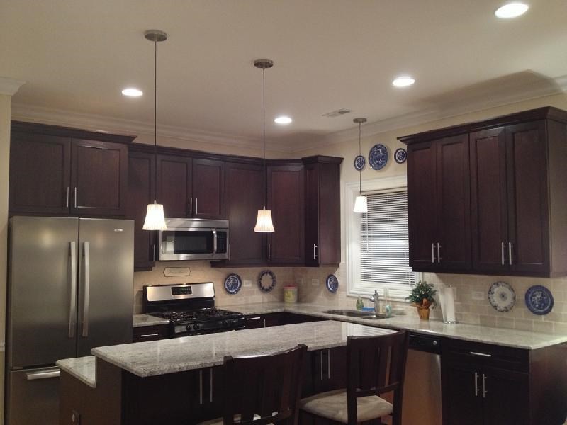a kitchen with a marble counter top and a stainless steel refrigerator