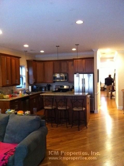 a kitchen and a living room with a table and chairs