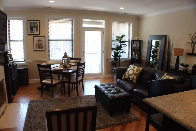 a living room and dining room with a table and chairs