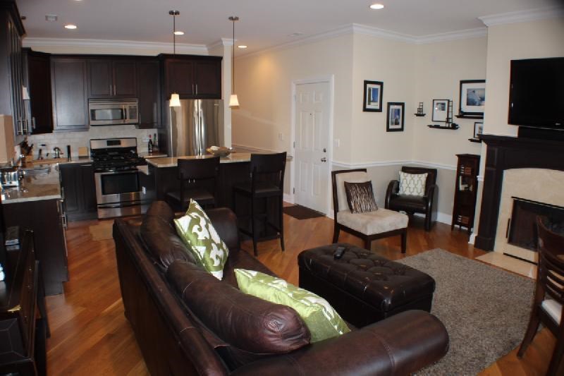 a living room and kitchen with leather furniture