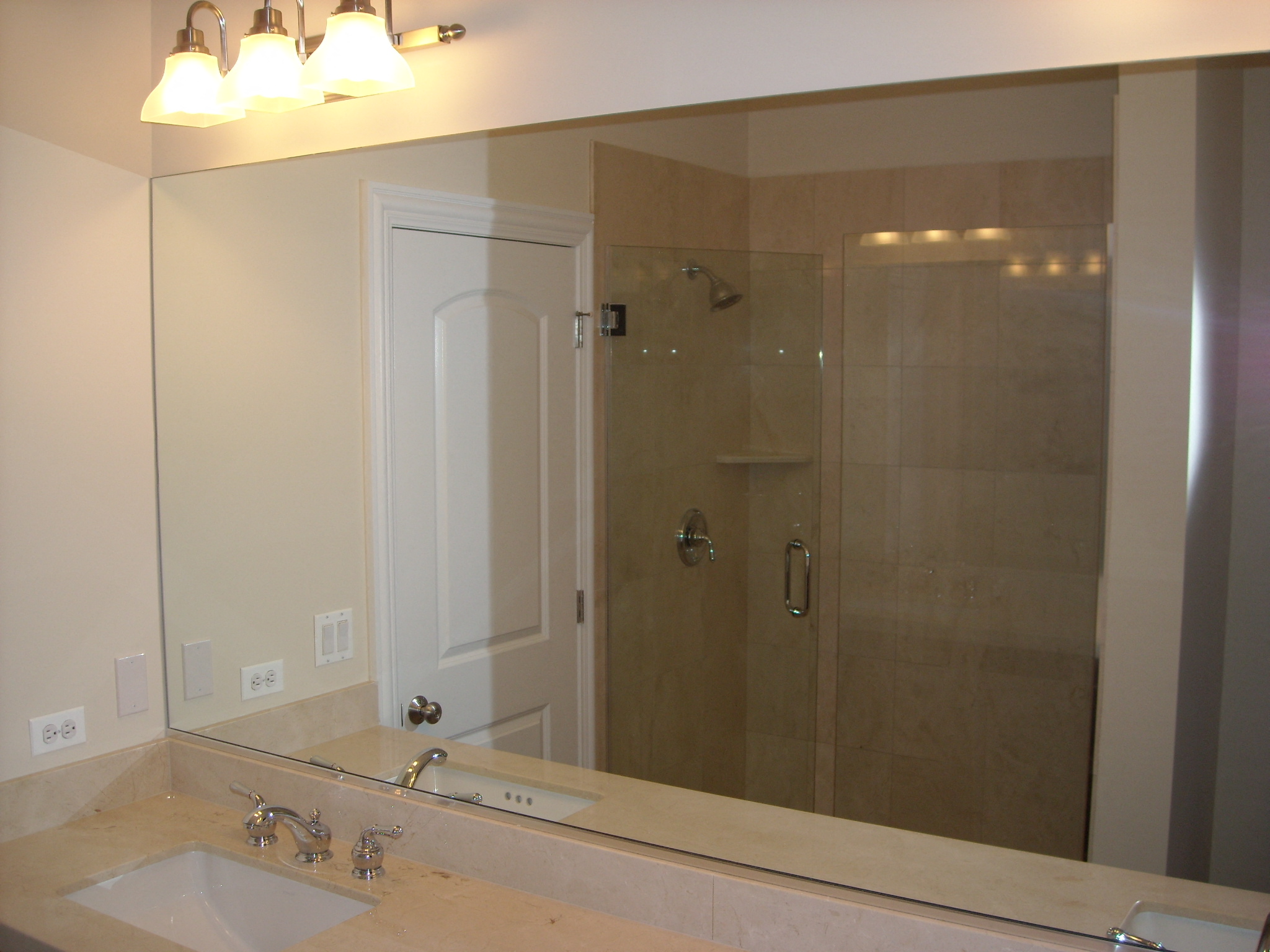 a bathroom with a large mirror and a shower