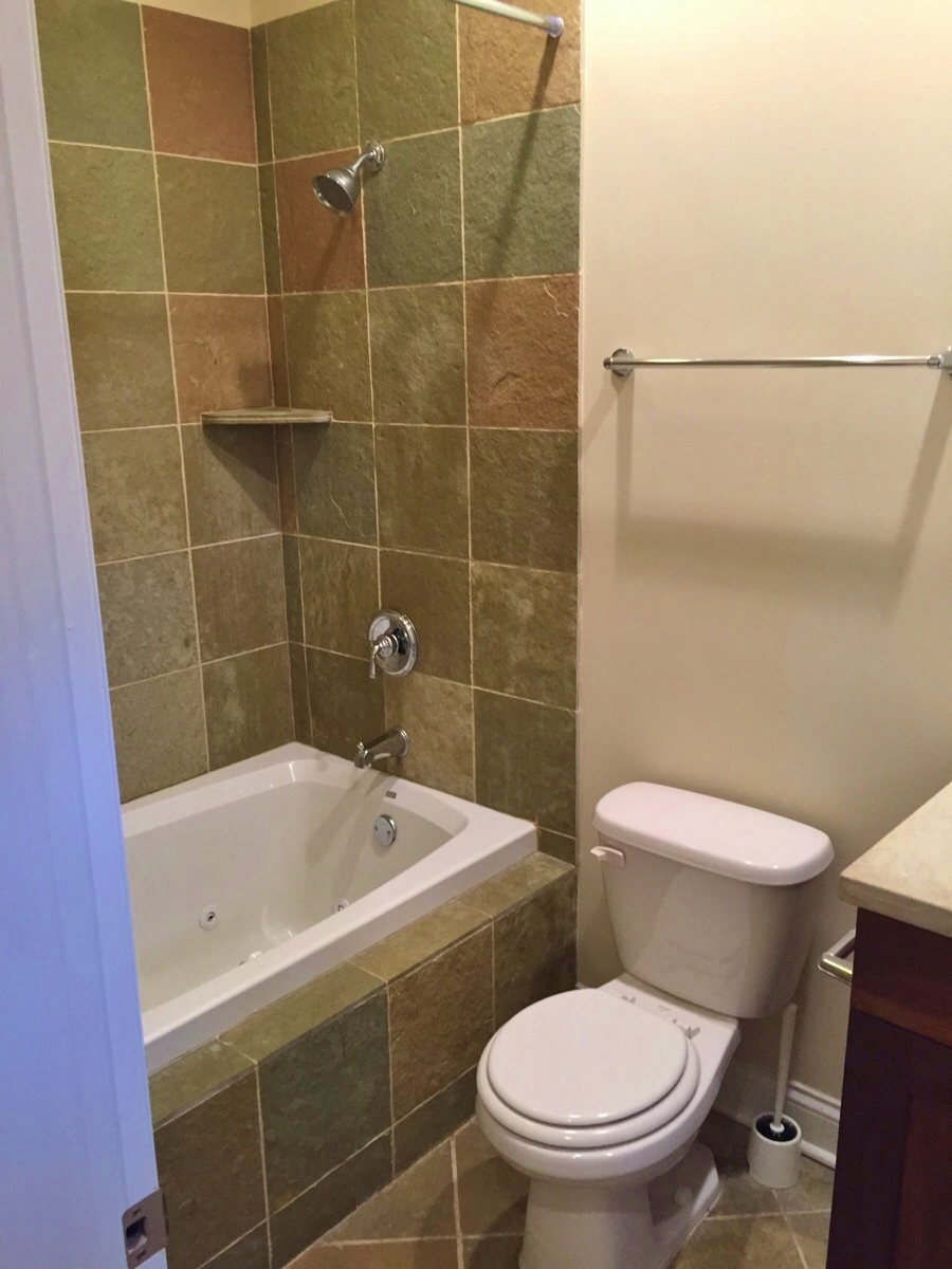a bathroom with a toilet and a tub and a sink