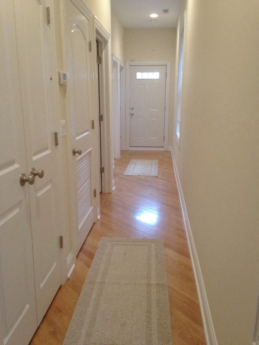 a hallway with white doors and a rug