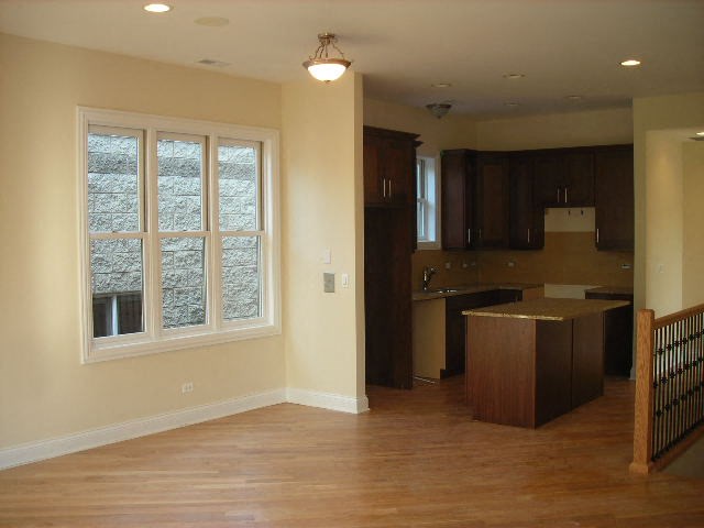 an empty room with a kitchen and a window