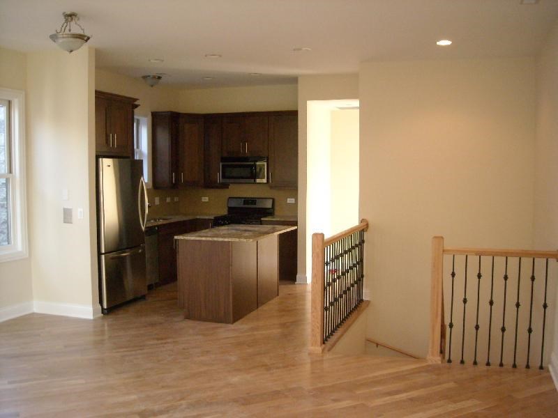 an empty kitchen with a stainless steel refrigerator
