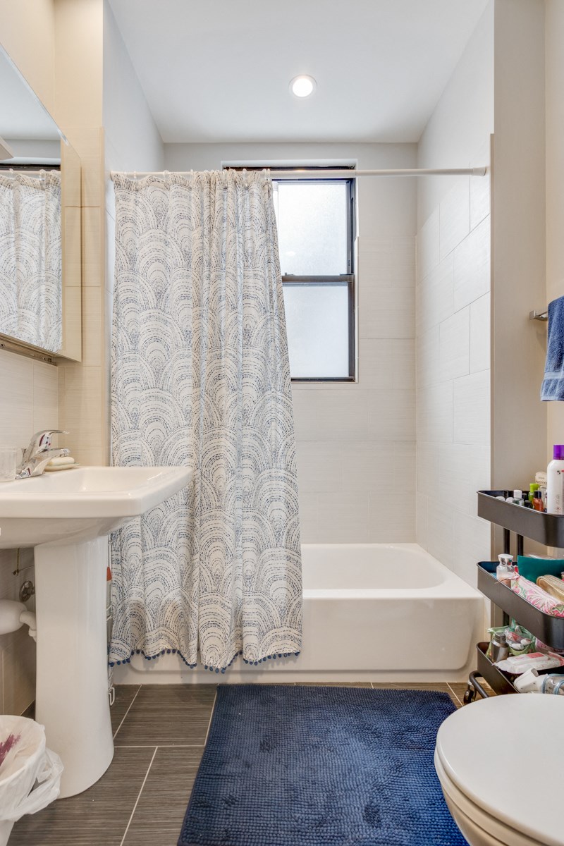 a bathroom with a shower curtain and a sink and a toilet