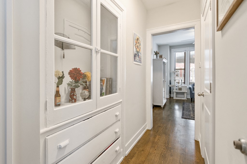 a view of a hallway with white cabinets and glass doors