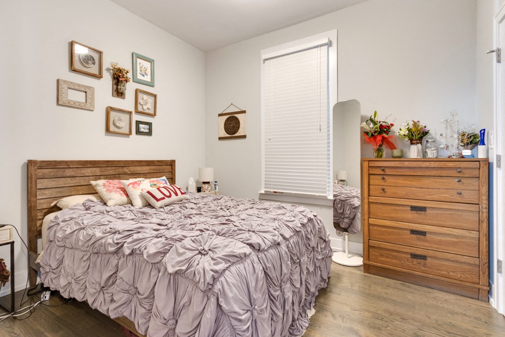 a bedroom with a bed and a dresser and a window