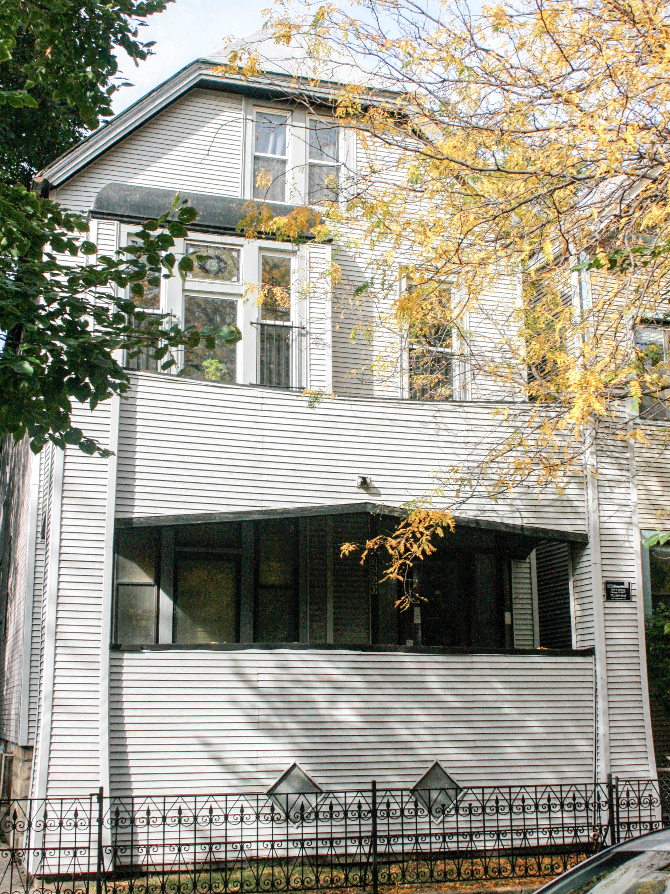 a white house with a black fence in front of it