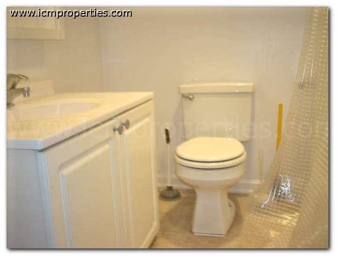 a bathroom with a white toilet and a sink