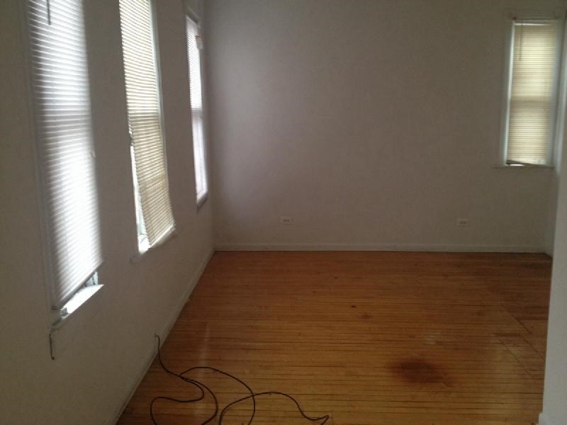 a empty room with a wooden floor and windows