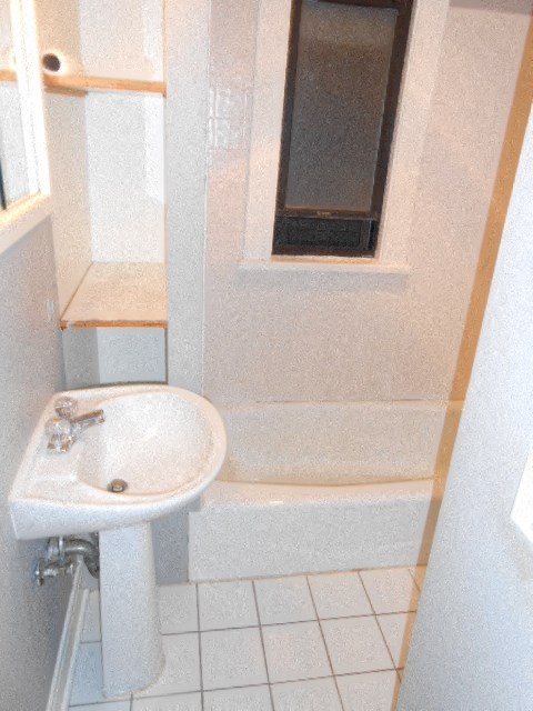 a white bathroom with a sink and a window