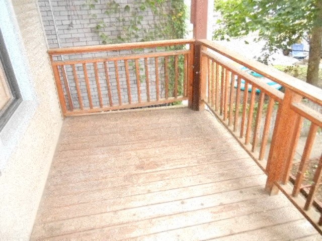 a balcony with a wooden railing and a tree