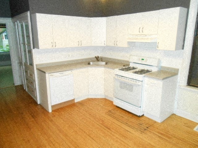 an empty kitchen with a stove and a sink
