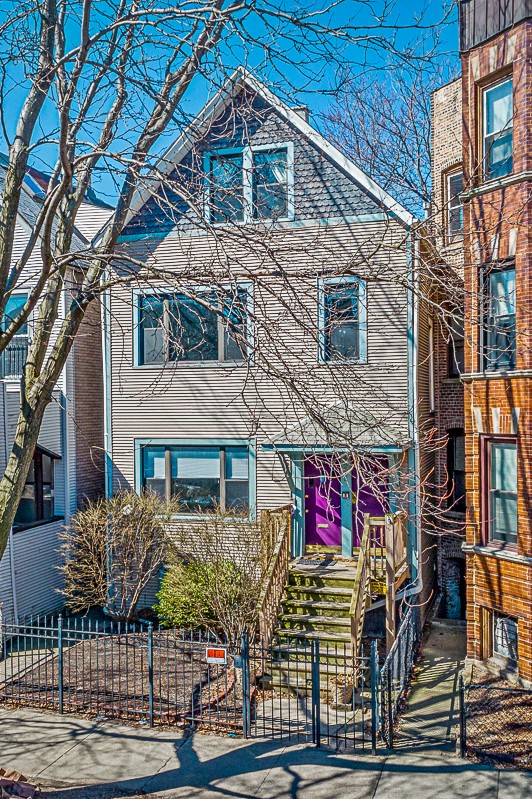 a white house with a purple door and stairs