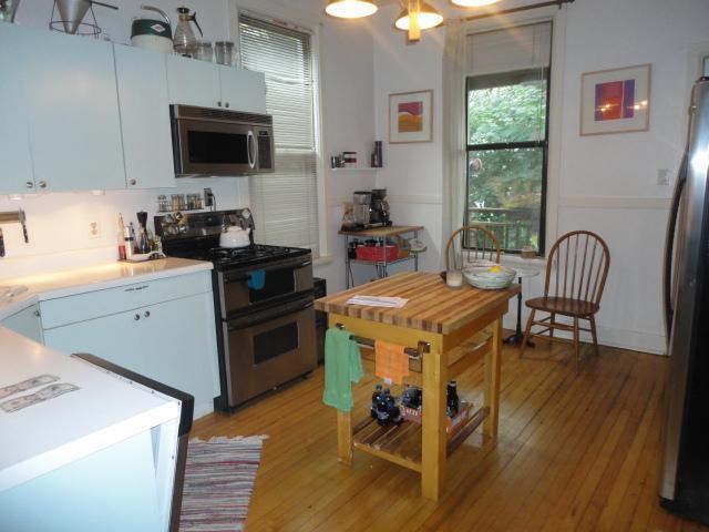 a kitchen with a wooden table in the middle