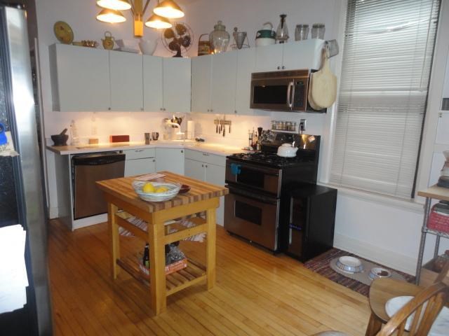 a kitchen with white cabinets and a wooden table