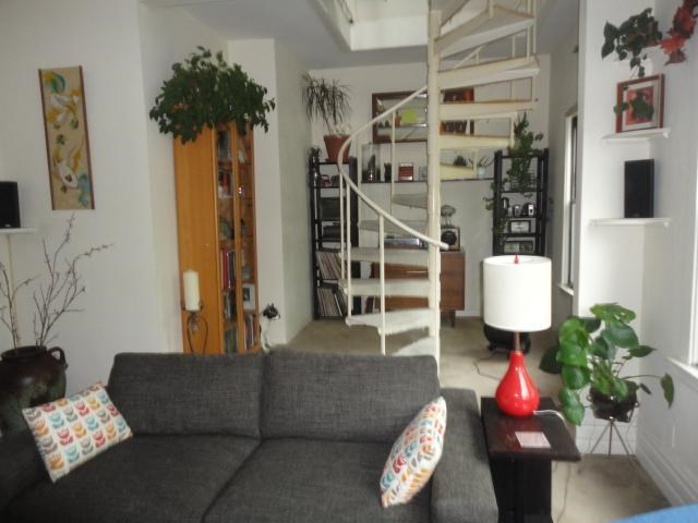 a living room with a couch and a spiral staircase
