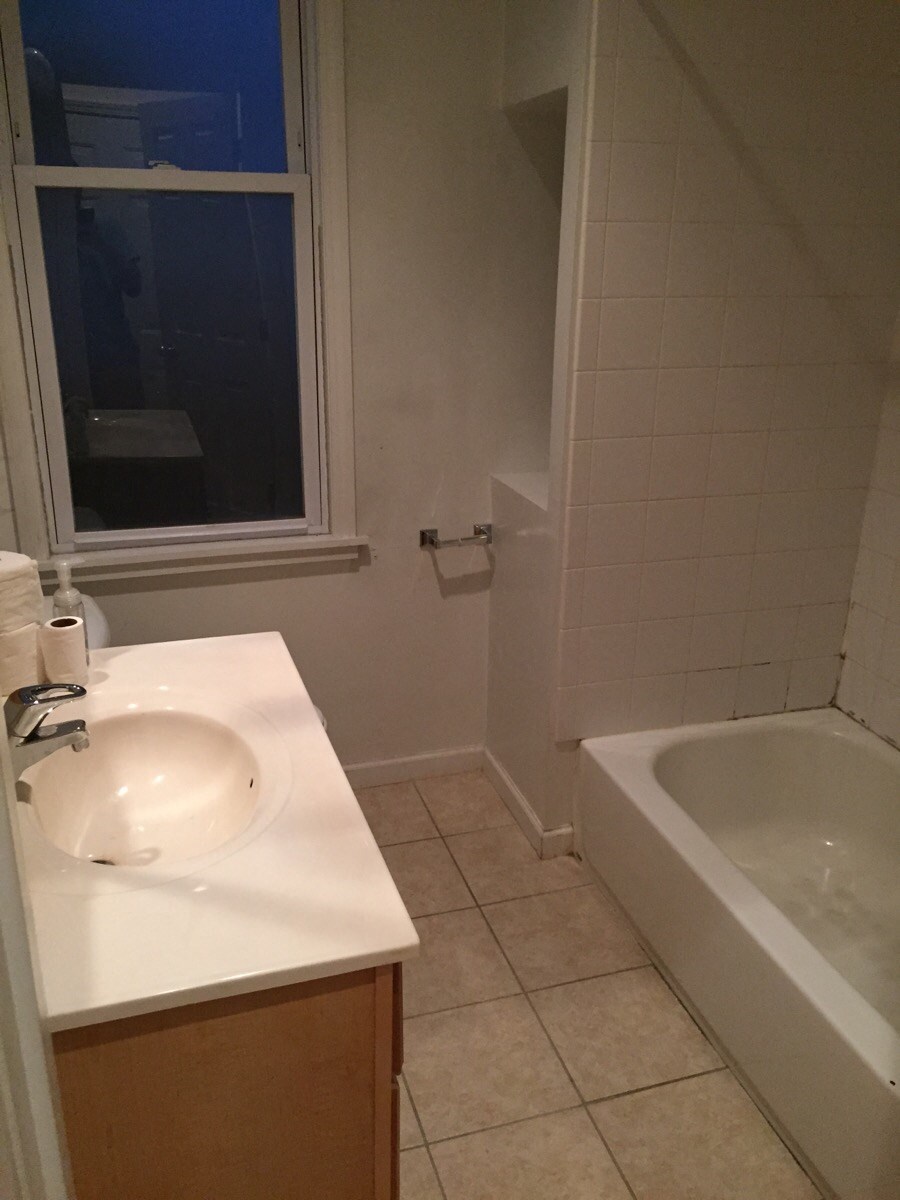 a bathroom with a sink and a tub and a window