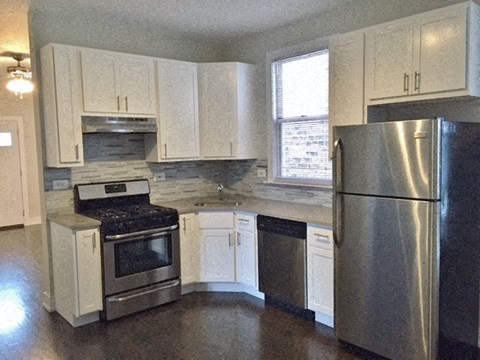 a kitchen with stainless steel appliances and white cabinets