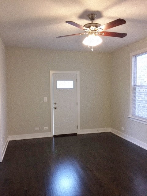 an empty room with a ceiling fan and a door