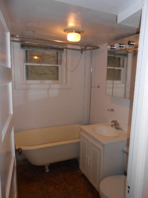 a bathroom with a tub and a sink and a toilet