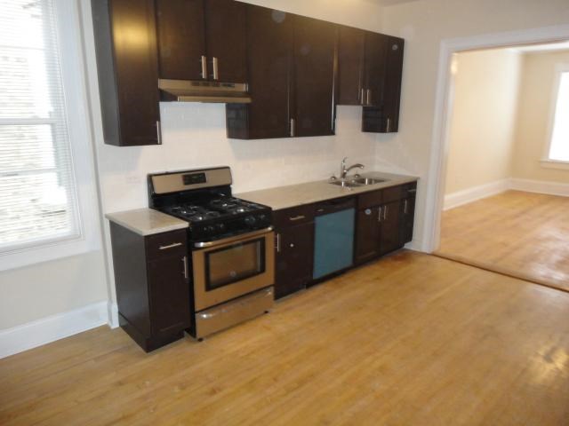 an empty kitchen with a stove and a sink