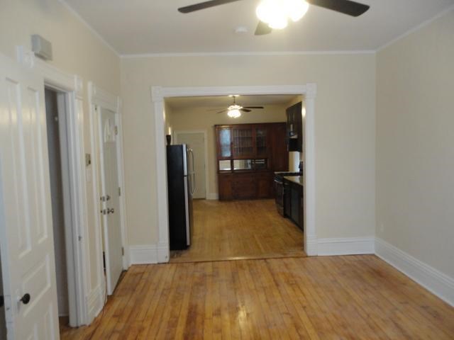 a living room and kitchen with a wood floor