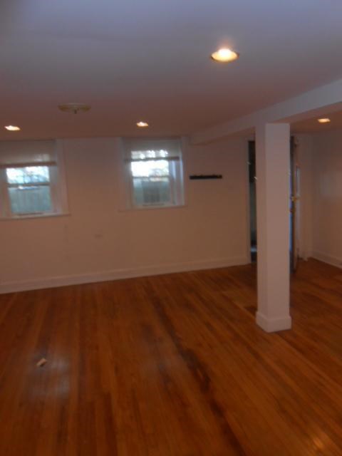 an empty living room with a hard wood floor