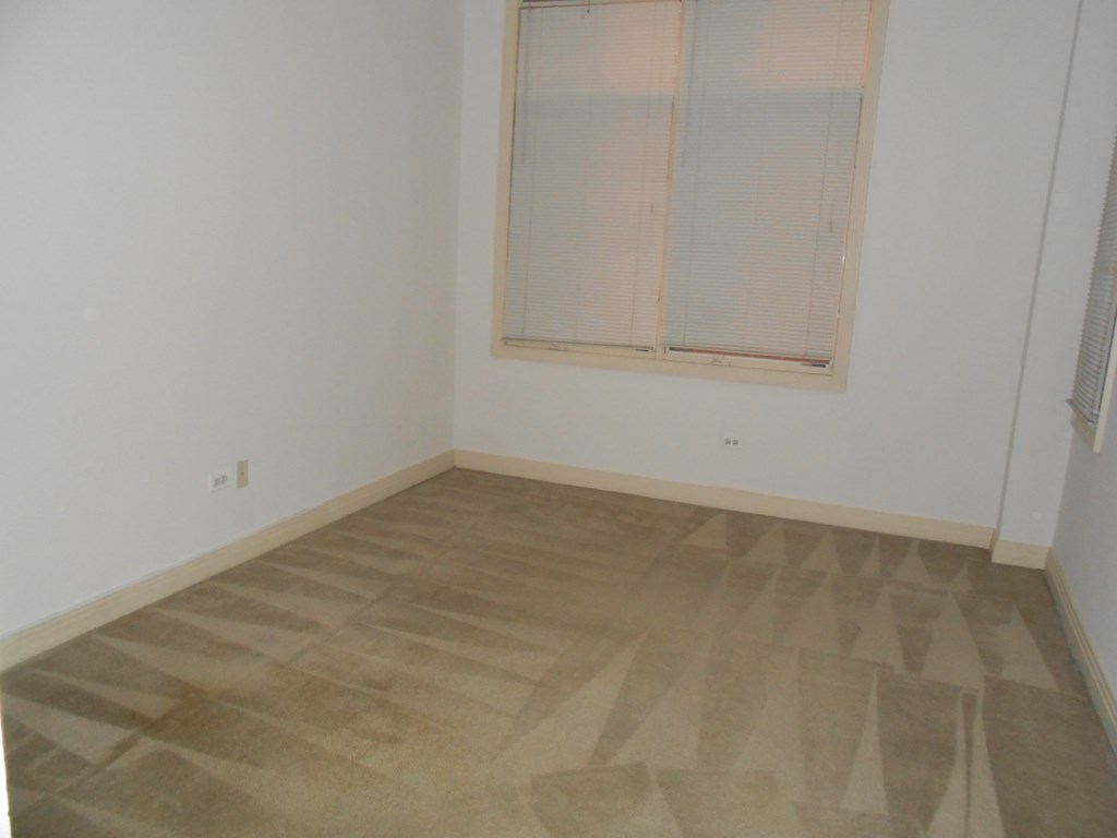 an empty room with white walls and a window
