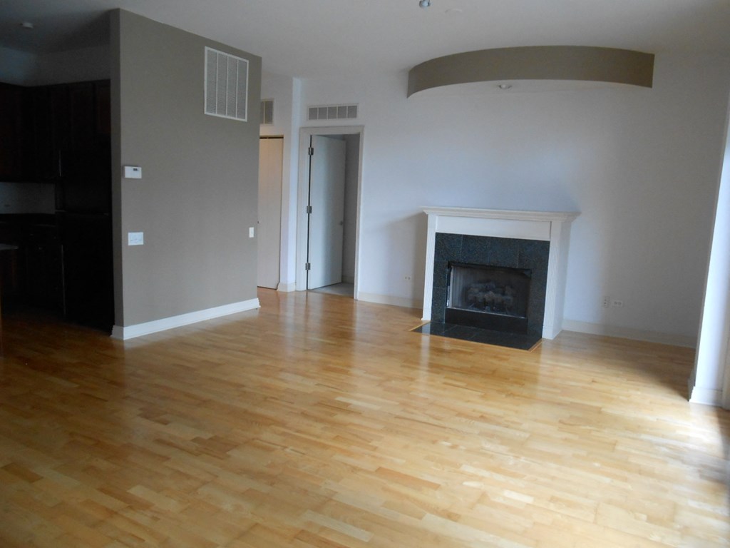 a living room with a fireplace and a wooden floor