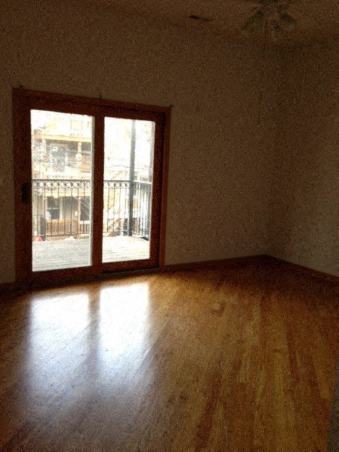 an empty living room with a wood floor and a window