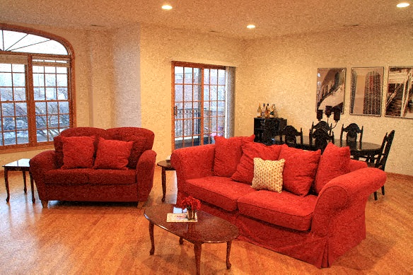 a living room with two red couches and a table