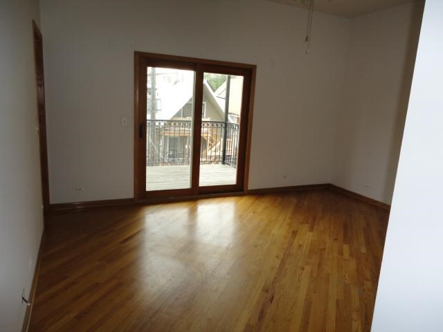 an empty living room with wood floors and a sliding glass door
