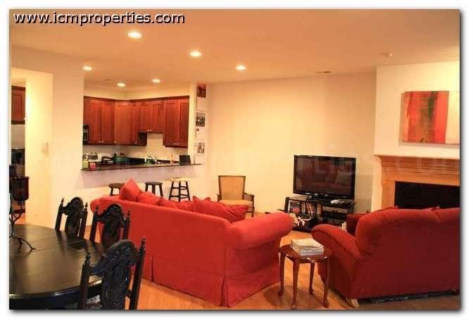 a living room with red couches and a table
