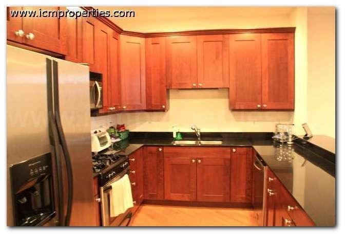 a kitchen with wooden cabinets and a stainless steel refrigerator