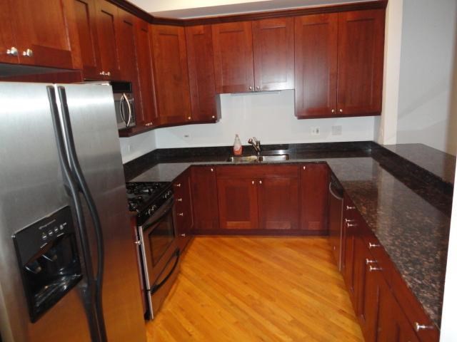 a kitchen with wooden floors and stainless steel appliances