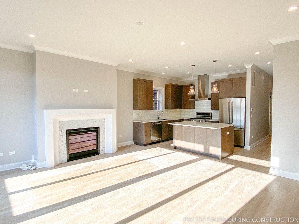 a large kitchen with a fireplace in the center of it