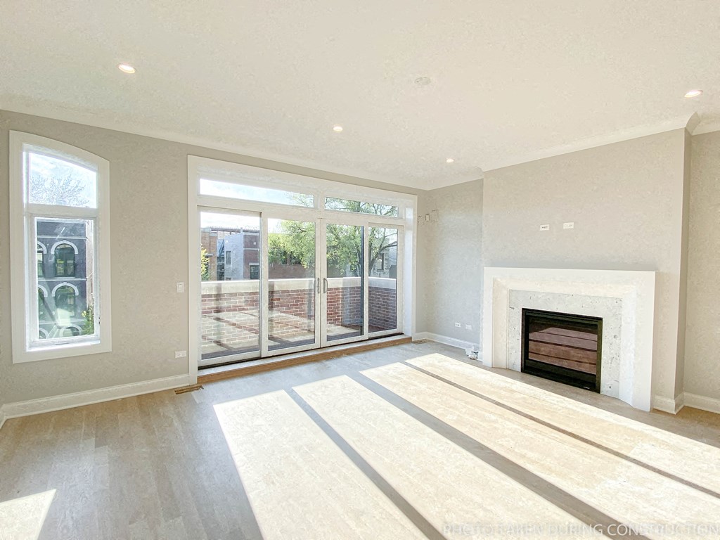 an empty living room with a fireplace and sliding glass doors