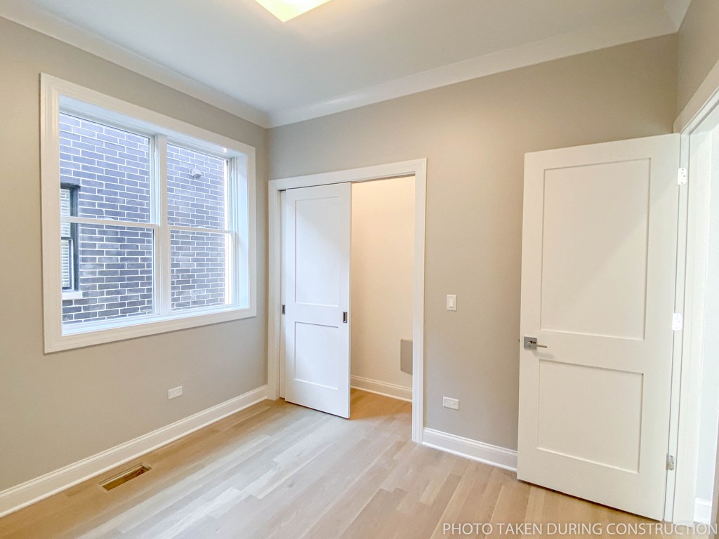 a bedroom with a door and a window and a door to a closet