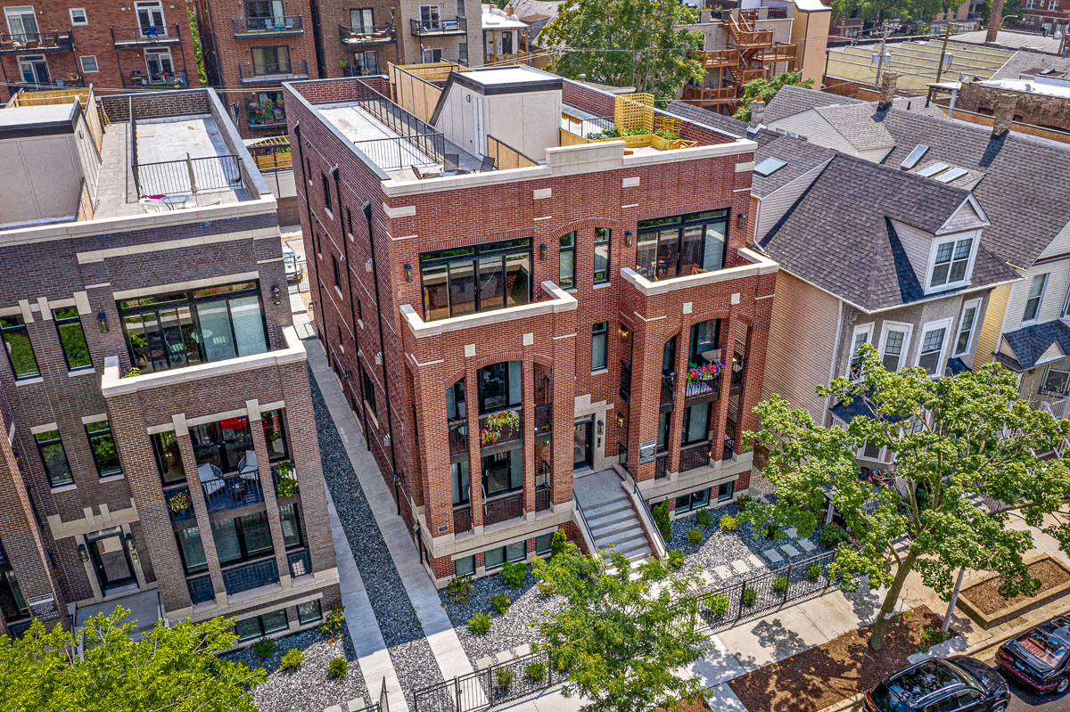 an aerial view of a red brick apartment building with stairs