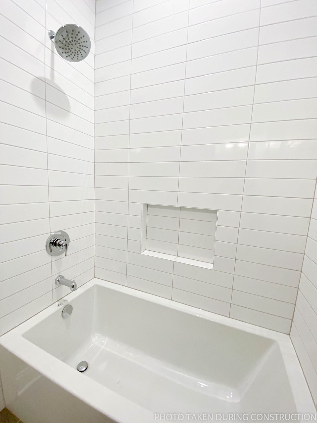 a small white bathroom with a tub and a shower